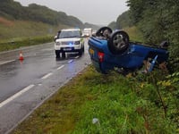 Car ends up on roof in heavy rain on A38