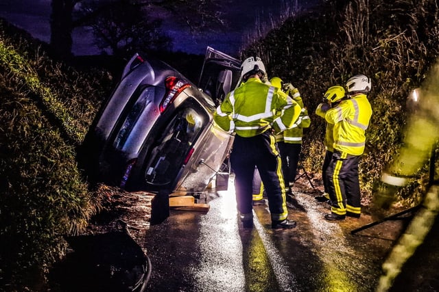 Fire crews help man escape as car ends up on its side