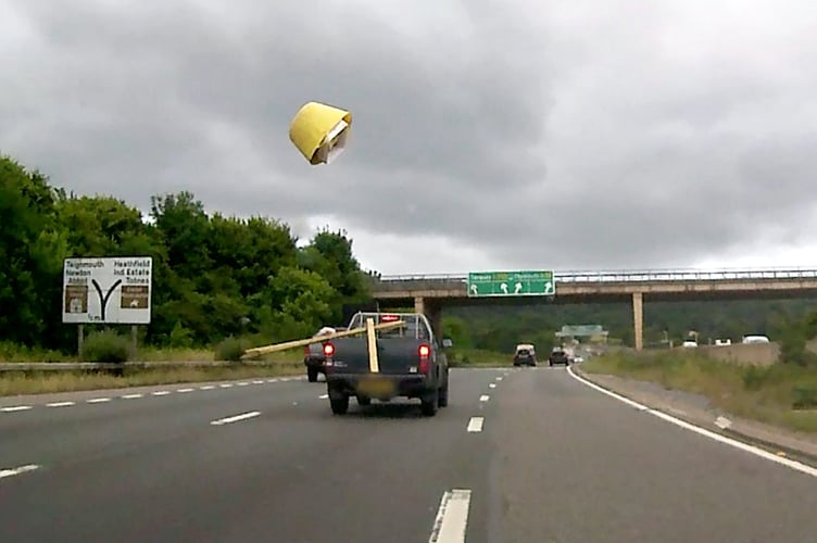 A still from Op Snap footage submitted to Devon & Cornwall Police shows an insecure load flying onto the A38. This video shows the moment a dangerous driver sent a bucket flying from the back of their van - catapulted by some loose planks. See SWNS story SWMRtraffic. The scary moment is one of thousands of clips sent to to police - showing reckless driving in Devon and Cornwall. They include dangerous overtakes, overloaded lorries and motorists speeding through red lights. One clip shows a tyre coming loose from a tractor towing a trailer - and being dragged down the carriageway. In another wooden planks send a bucket flying on the A38 dual carriageway. A spokesman for Devon and Cornwall Polices Head of Road Safety, said: Both of these incidents could have been far worse and resulted in death or serious injury.''