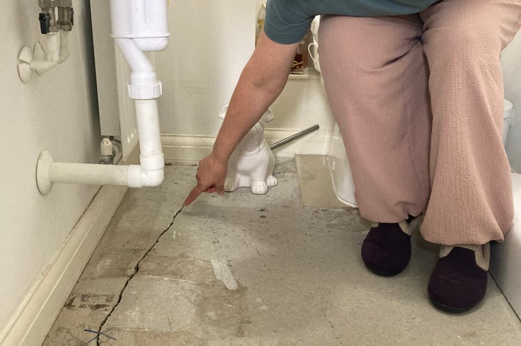 Dayle shows one of the cracks in the floor