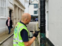 Neil paints bollard protecting special building in Totnes