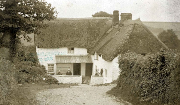 Home Park thatched house 1890. 
Two people leaning on garden wall.