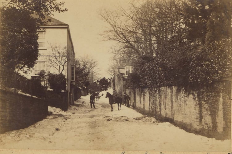 March 1891. Looking north up Fore Street, Kingsbridge, with Knowle House garden wall on right. People in road after the blizzard