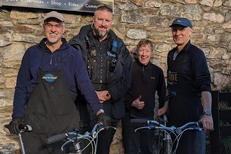 PC Barnaby Geary, who applied for POCA funds, with volunteers at the Totnes Bike Hub. 