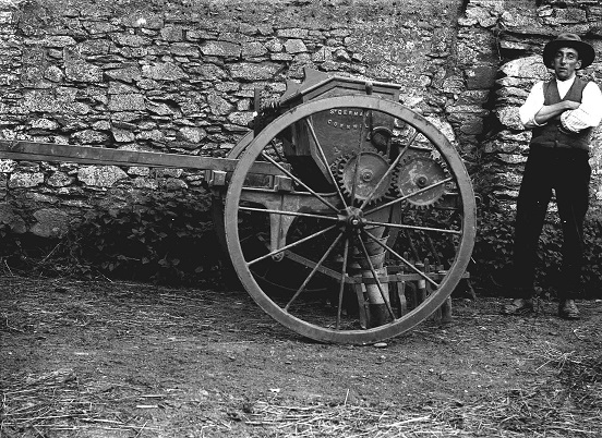 Seed drill with worker standing by