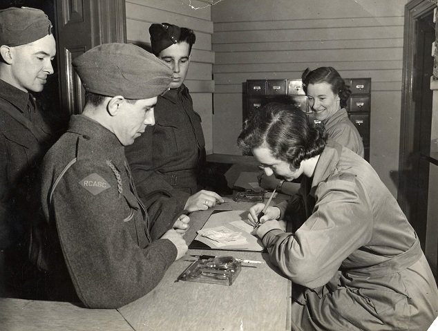 Three Canadian soldiers registering at the Beaver Club in London where soldiers on leave were looked after.
January 1942.
