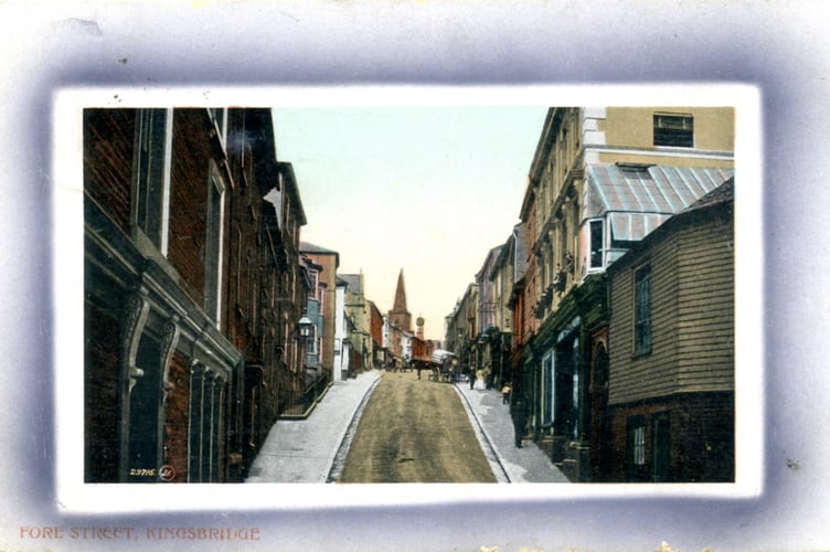 1910 looking up hill from Brittons Corner, Fore Street, Kingsbridge. People and a horse and wagon in scene. 