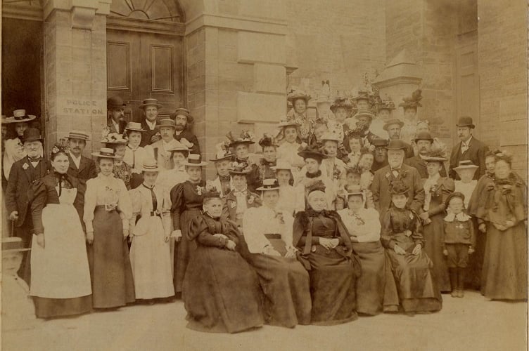 Around 1890 group of men and women gathered in front of Town Hall and steps to St Edmund’s Church, Fore Street, Kingsbridge.