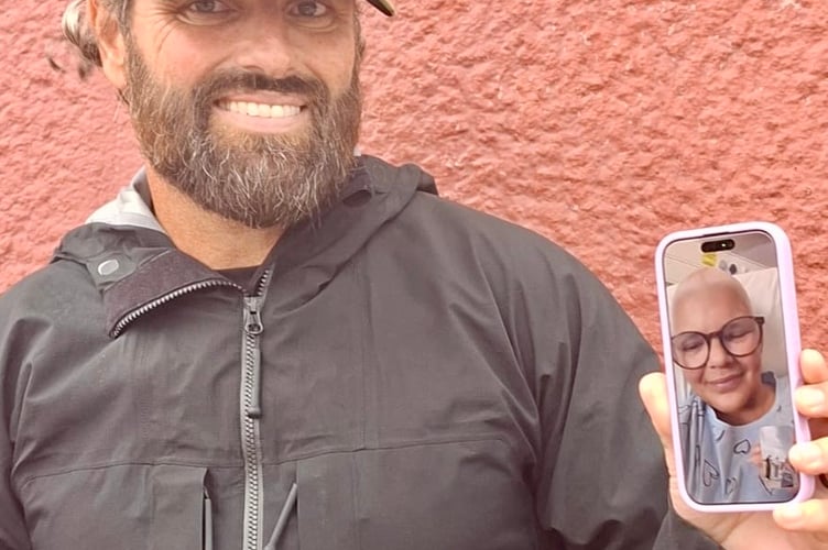 Liam Aitchison facetiming his sister, Eilidh, at the finish line in Plymouth.
